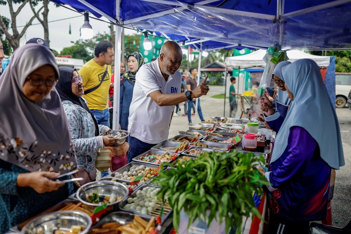 RAJA Mohamed Affandi (tengah) ketika bertemu peniaga pasar malam di Pasar Malam Kampung Paya Berenjut sempena kempen PRK Parlimen Kemaman hari ini. FOTO Bernama