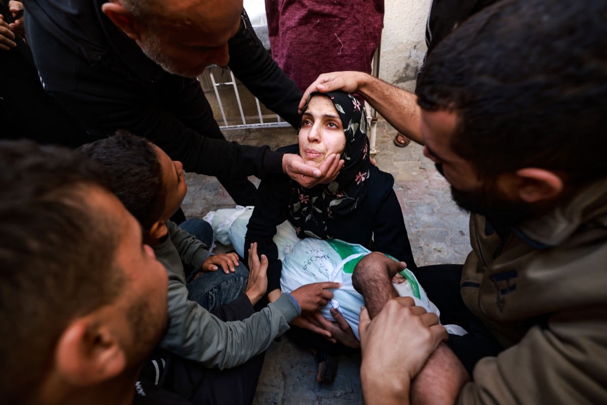 ORANG ramai cuba menenangkan wanita yang sedang memeluk jenazah anak perempuannya  yang terbunuh dalam serangan udara Israel di Rafah di Hospital al-Najjar. FOTO AFP