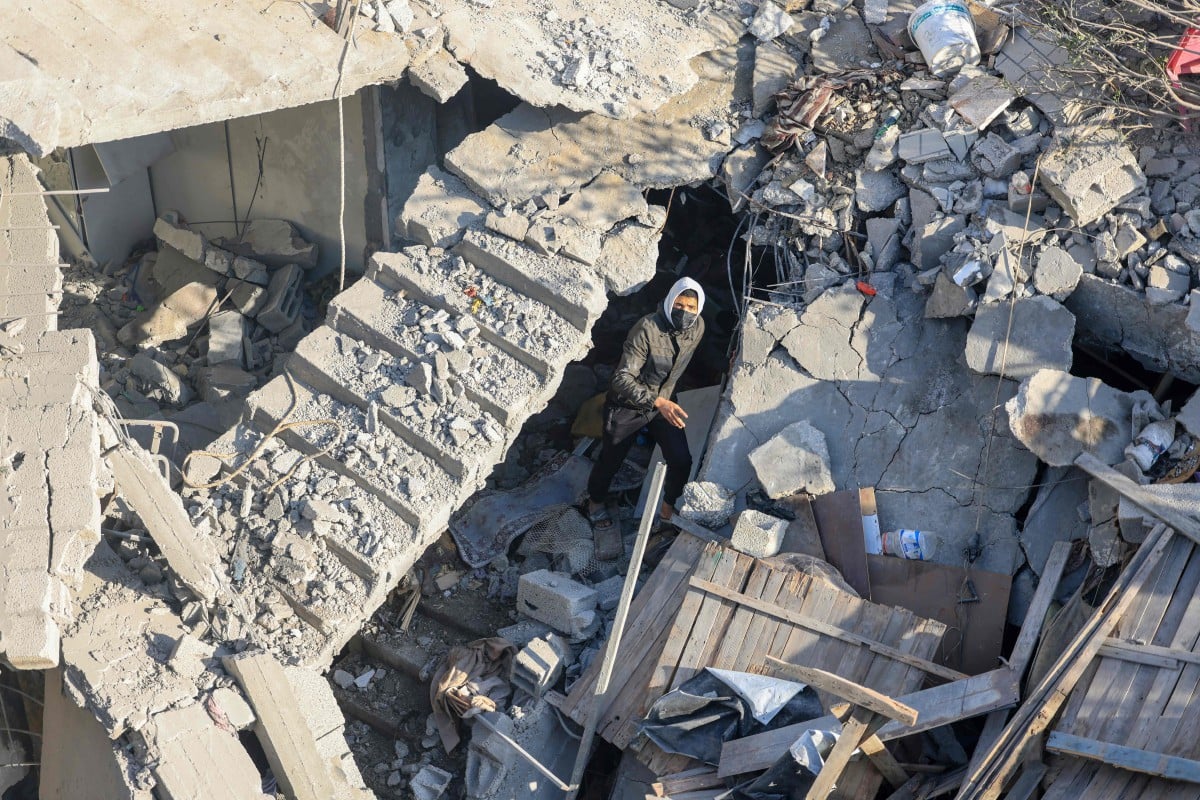 LELAKI berjalan di antara runtuhan bangunan yang musnah di Rafah. FOTO AFP