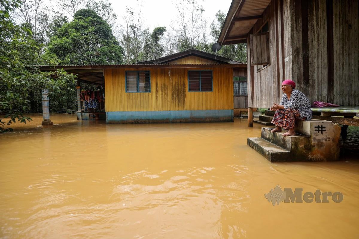 PENDUDUK, Maznah Osman, melihat persekitaran rumahnya yang ditenggelami banjir di Kampung Nibong, Hulu Terengganu. FOTO Ghazali Kori