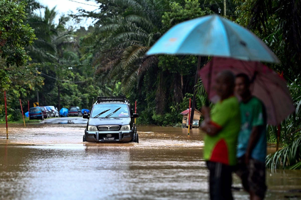 SEBUAH kenderaan meredah banjir selepas kawasan berkenaan dinaiki air ketika tinjauan di Kampung Kepah hari ini. FOTO Bernama