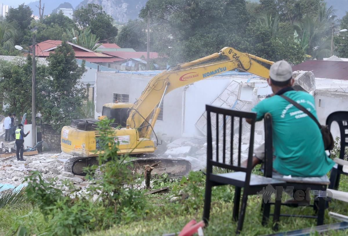 SEORANG lelaki melihat operasi merobohkan rumah untuk projek ECRL di Kampung Desa Mukmin Warisan, Sungai Pusu. FOTO Fathil Asri.