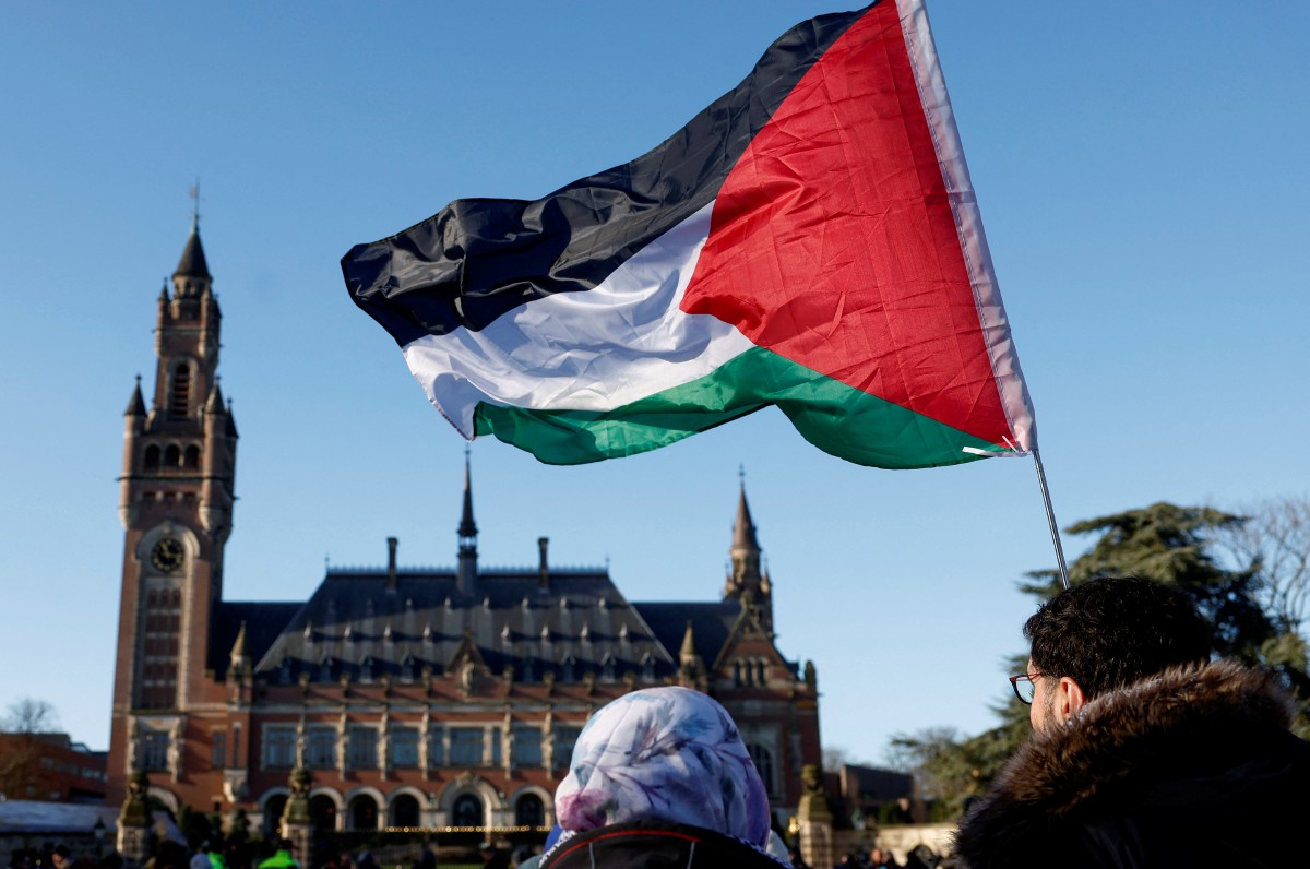 BENDERA Palestin dikibarkan dalam protes di hadapan bangunan ICJ. FOTO Reuters.