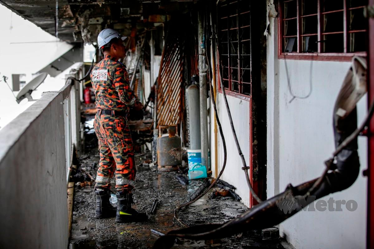 ANGGOTA Unit Forensik Jabatan Bomba dan Penyelamat Malaysia melakukan kerja pemeriksaan punca kebakaran enam unit rumah di Blok 70, Flat Sri Sabah, Cheras. FOTO Aizuddin Saad