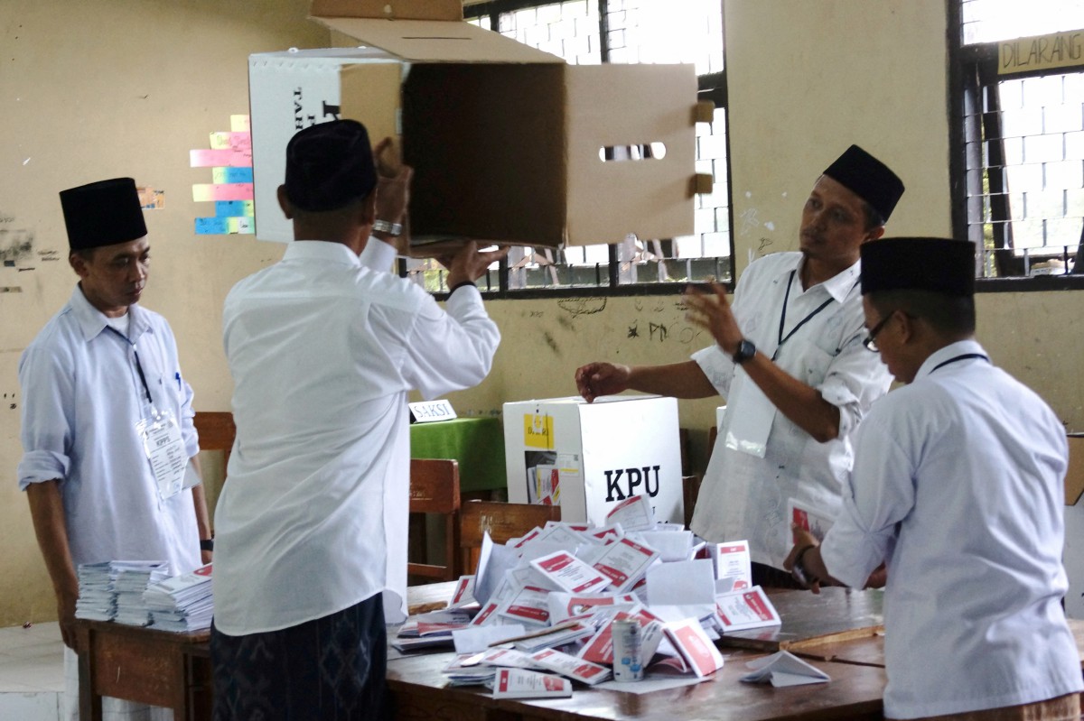 PEGAWAI pilihan raya mengira kertas undi di pusat pengiraan undi di Jombang Regency,  Jawa Timur. FOTO Antara via Reuters.