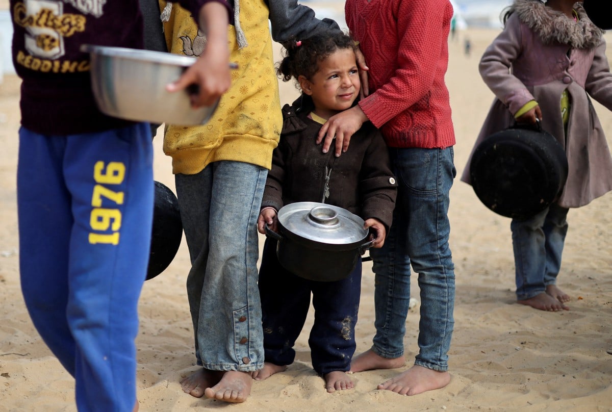 KANAK-kanak Palestin menunggu bekalan makanan di kawasan khemah mereka. FOTO Reuters