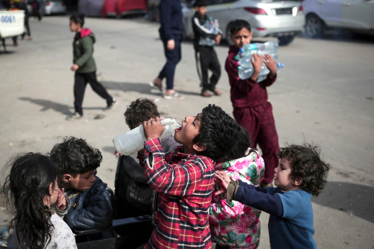 KANAK-kanak Palestin menikmati minuman yang diperoleh. FOTO AFP