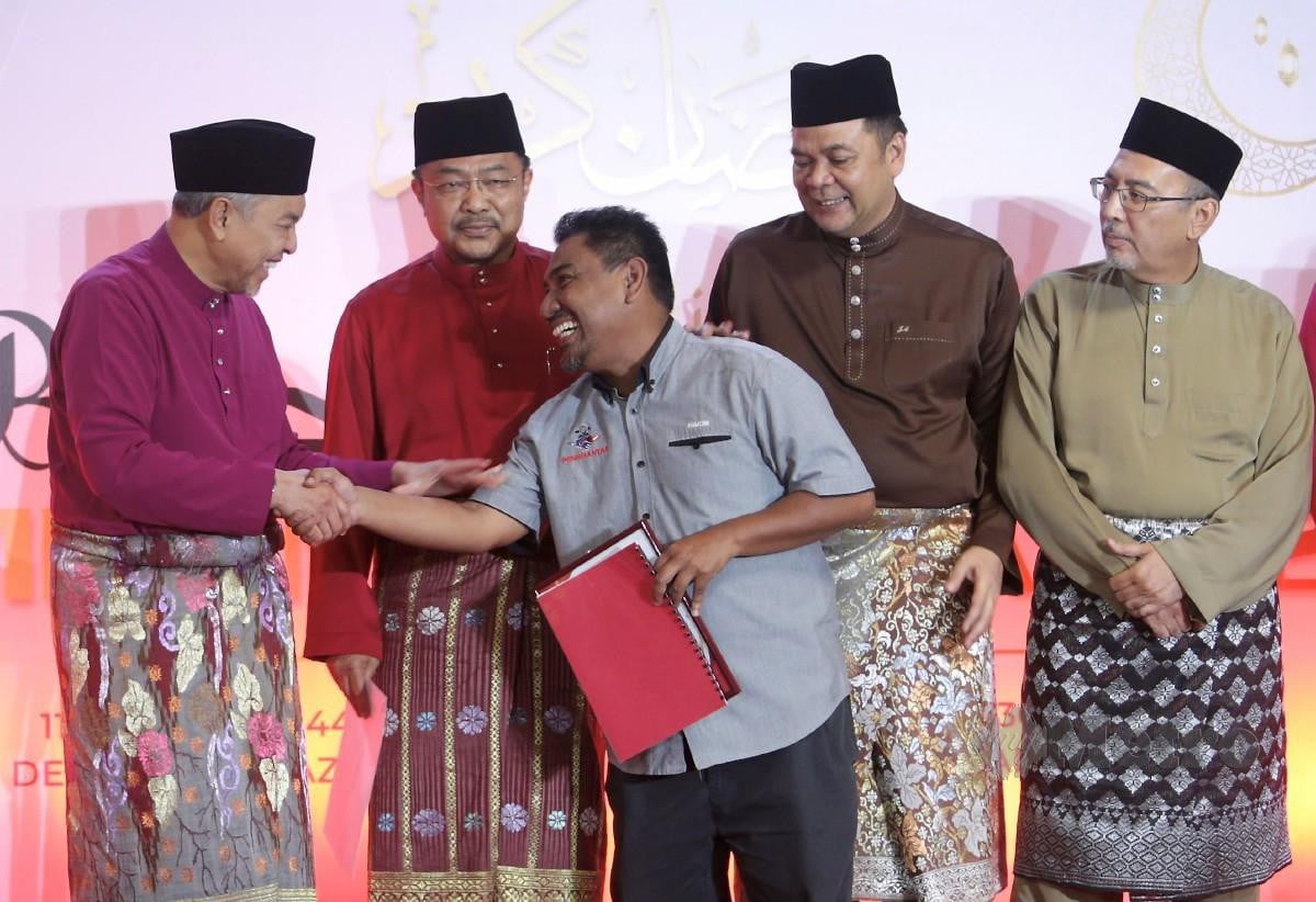 AHMAD Zahid menerima referendum daripada wakil pekerja ekonomi gig malaysia ketika Majlis Berbuka Puasa Majlis Kerja Tertinggi (MKT) Umno, di Menara Dato Onn, Pusat Dagangan Dunia (WTC) Kuala Lumpur, hari ini. FOTO Mohamad Shahril Badri Saali