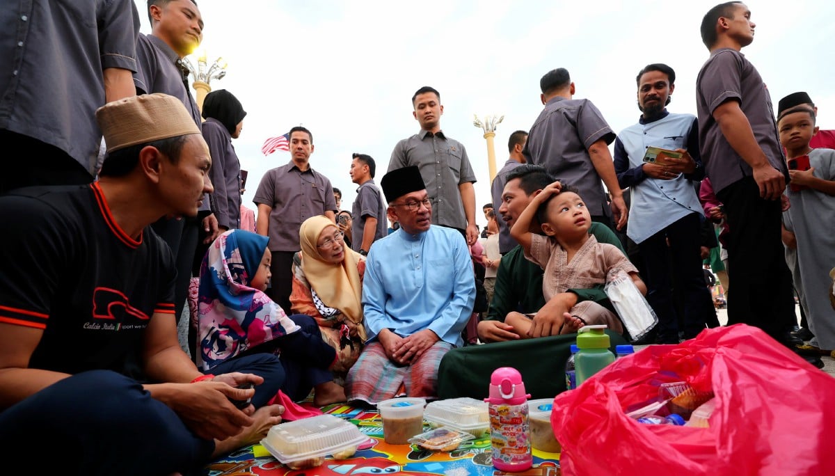 ANWAR (tengah) dan isteri Datuk Seri Dr Wan Azizah Wan Ismail menyantuni orang ramai yang hadir pada Majlis Iftar Madani (MIM) bersama Perdana Menteri di Dataran Putra, hari ini. FOTO Bernama