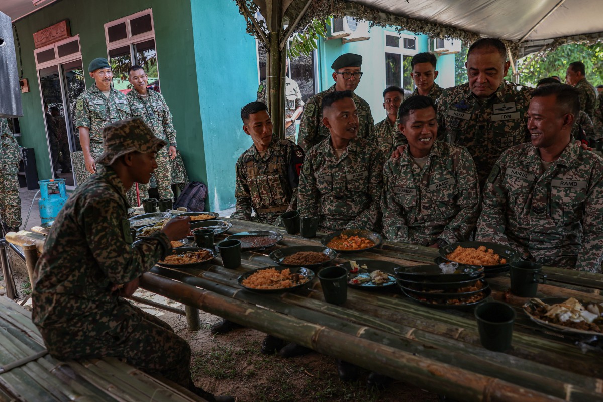 MUHAMMAD Hafizuddeain beramah mesra bersama anggota operasi Tentera Darat Malaysia sempena Majlis Sambutan Hari Raya Aidilfitri di Markas Taktikal Kem Gubir hari ini. FOTO Bernama