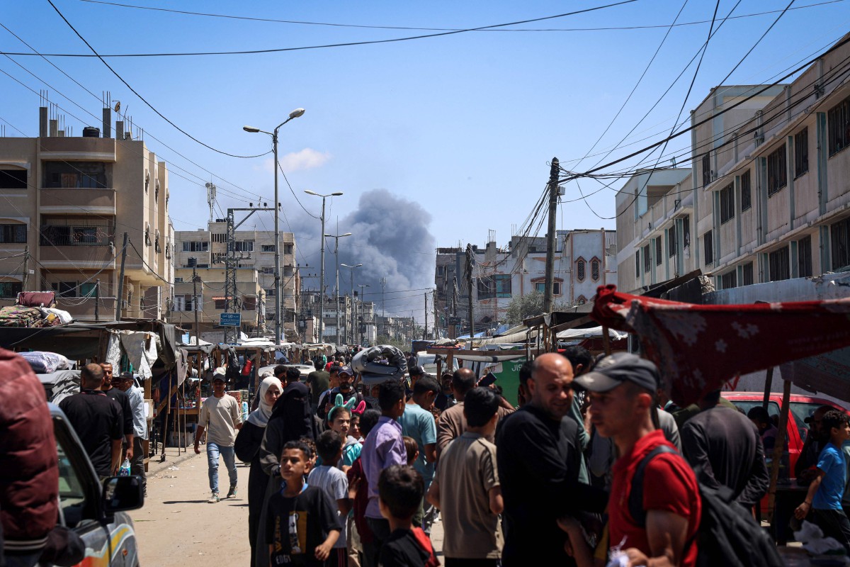 RAKYAT Palestin berkumpul di jalanan ketika asap menjulang ke udara susulan serangan Israel di Rafah. FOTO AFP