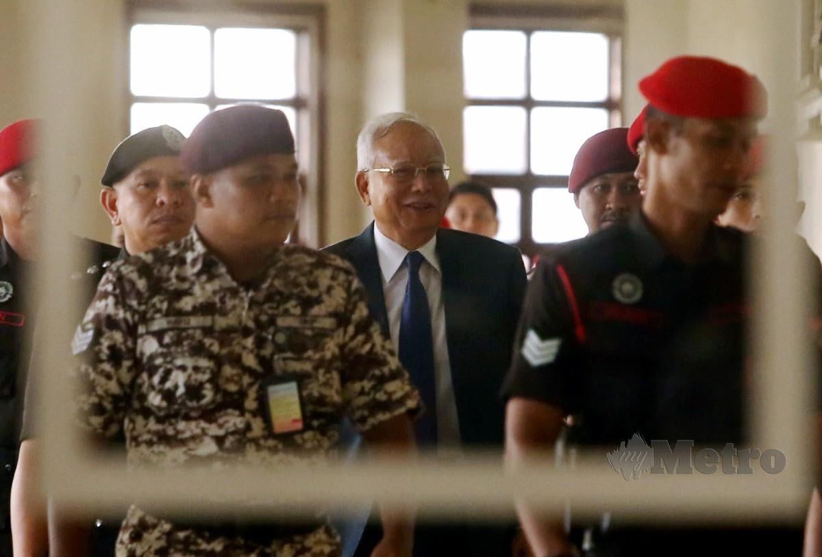 DATUK Seri Najib Razak diiringi pegawai Penjara ketika hadir ke mahkamah bagi sambung bicara kes saman SRC International di Mahkamah Tinggi Kuala Lumpur. FOTO Hairul Anuar Rahim
