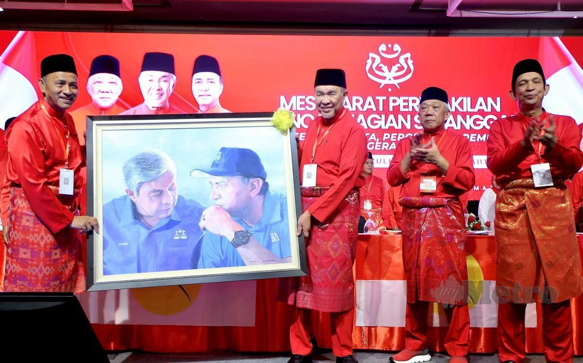 AHMAD Zahid (dua kiri) menerima cenderamata dari Yakub (kiri) sambil diperhatikan oleh Ketua Umno Sabah, Datuk Seri Bung Moktar Radin (dua kanan) selepas merasmikan Mesyuarat Perwakilan Umno Bahagian Sepanggar. FOTO Mohd Adam Arinin