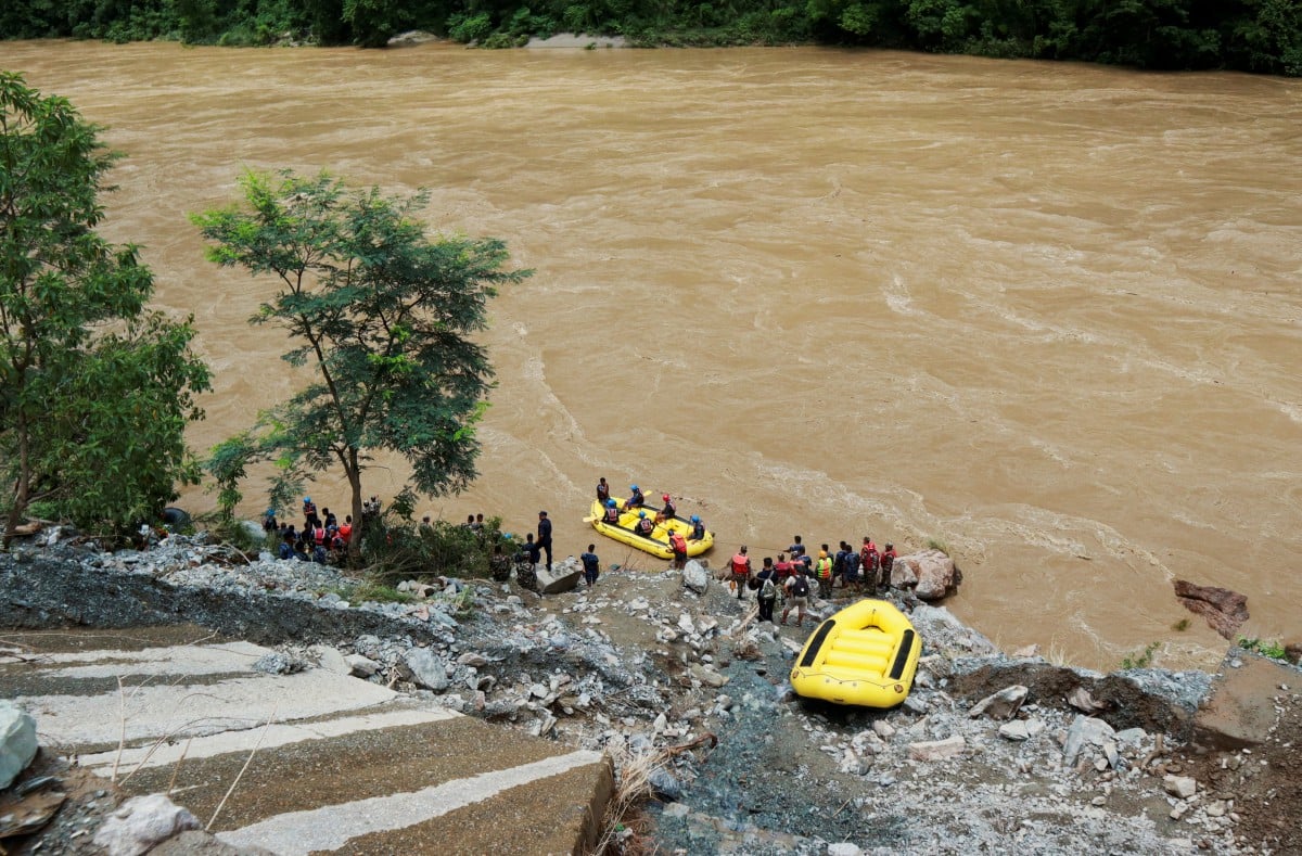 ANGGOTA penyelamat melancarkan operasi mencari dan menyelamat penumpang bas yang terjatuh ke dalam sungai Trishuli selepas tanah runtuh. FOTO Reuters