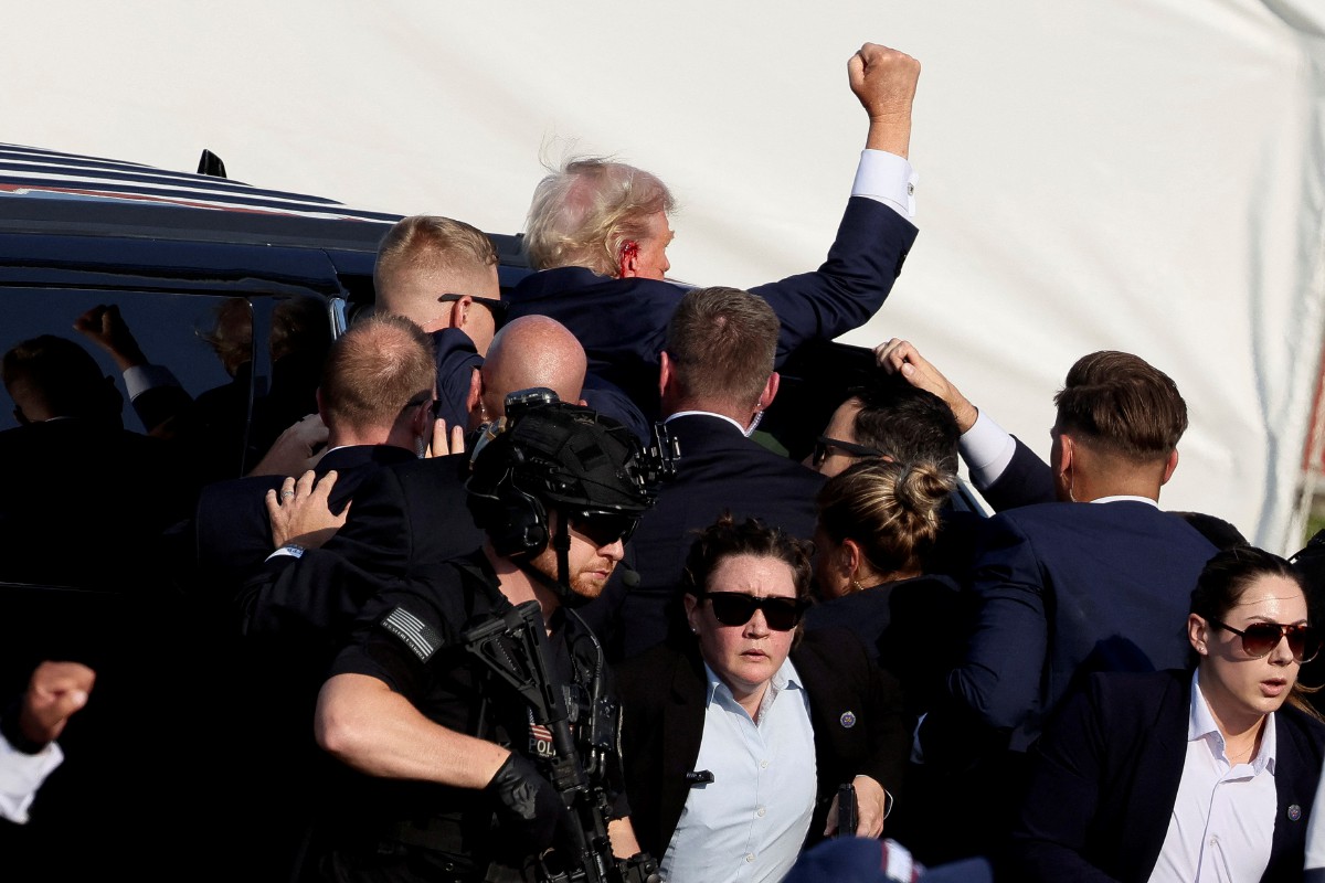 TRUMP dibawa ke kenderaan selepas terkena tembakan ketika berkempen di Butler, Pennsylvania. FOTO Reuters