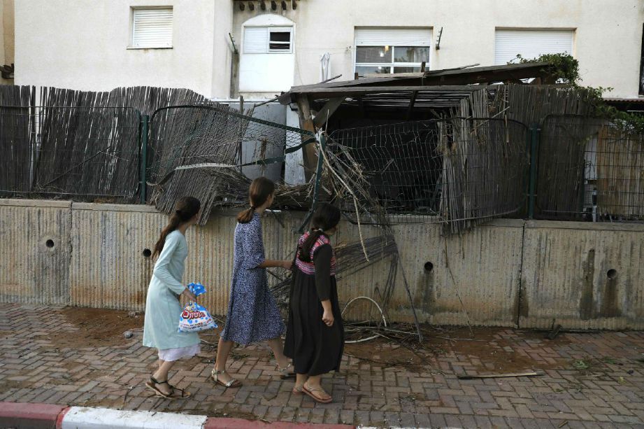 KANAK-kanak melihat kemusnahan yang berlaku di Sderot, selatan Israel. Foto/AFP
