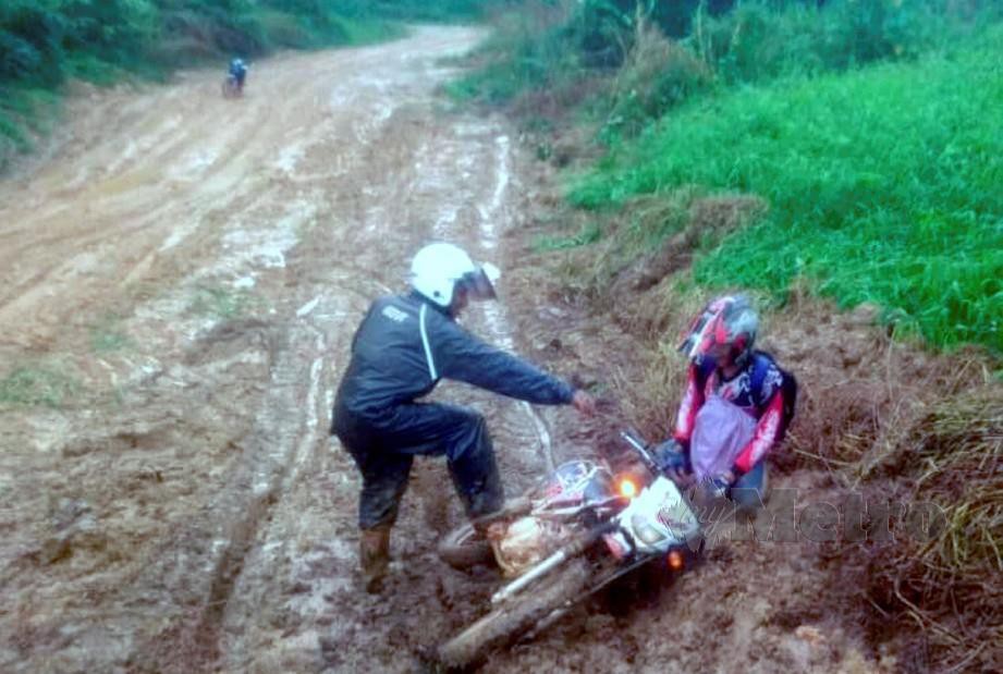KAKITANGAN Sekolah Kebangsaan (SK) Tohoi sering jatuh motosikal ketika melalui jalan licin dan berselut dari jalan Kuala Betis ke Pos Tohoi sejauh 20 kilometer kerana hujan musim tengkujuh. FOTO Ramli Ibrahim