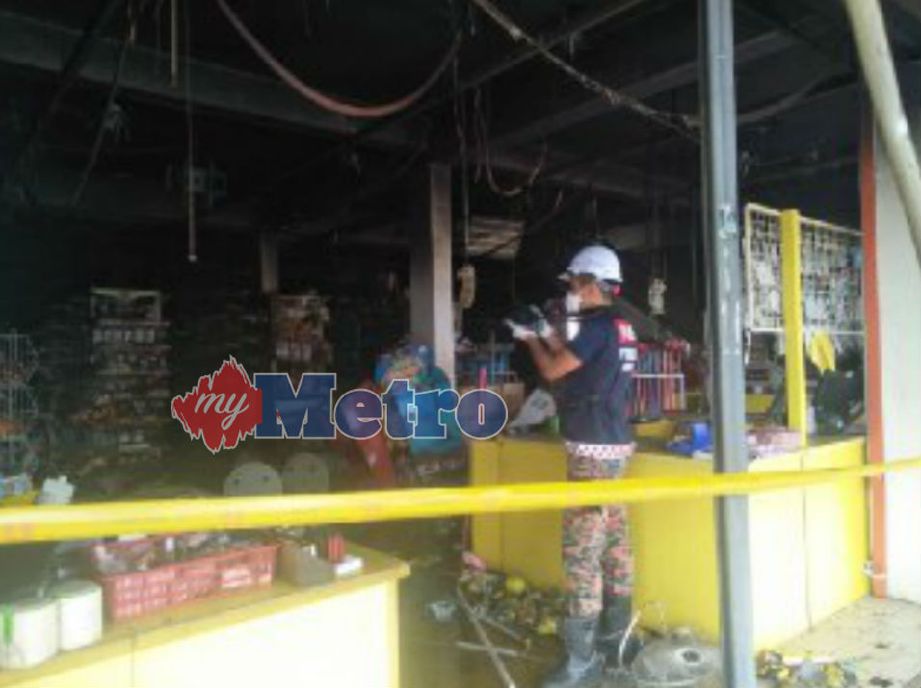 PEGAWAI bomba menjalankan siasatan di lokasi kebakaran di tingkat bawah sebuah kedai di Jalan Tandop yang terbakar awal pagi tadi. Foto STR/ZULIATY ZULKIFFLI
