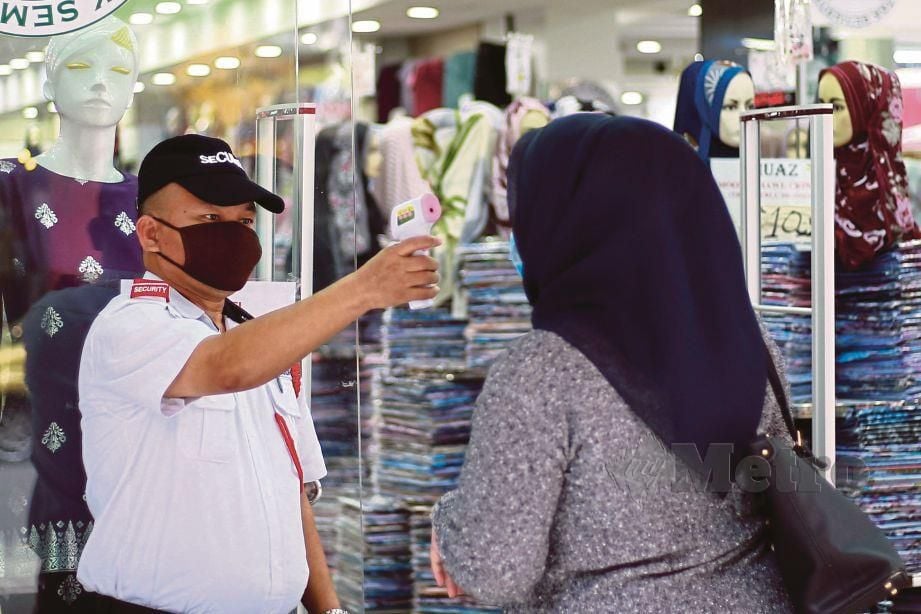 SUHU badan pelanggan dipambil sebelum memasuki premis perniagaan yang telah dibuka dalam tempoh Perintah Kawalan Pergerakan Bersyarat (PKPB). FOTO Asyraf Hamzah