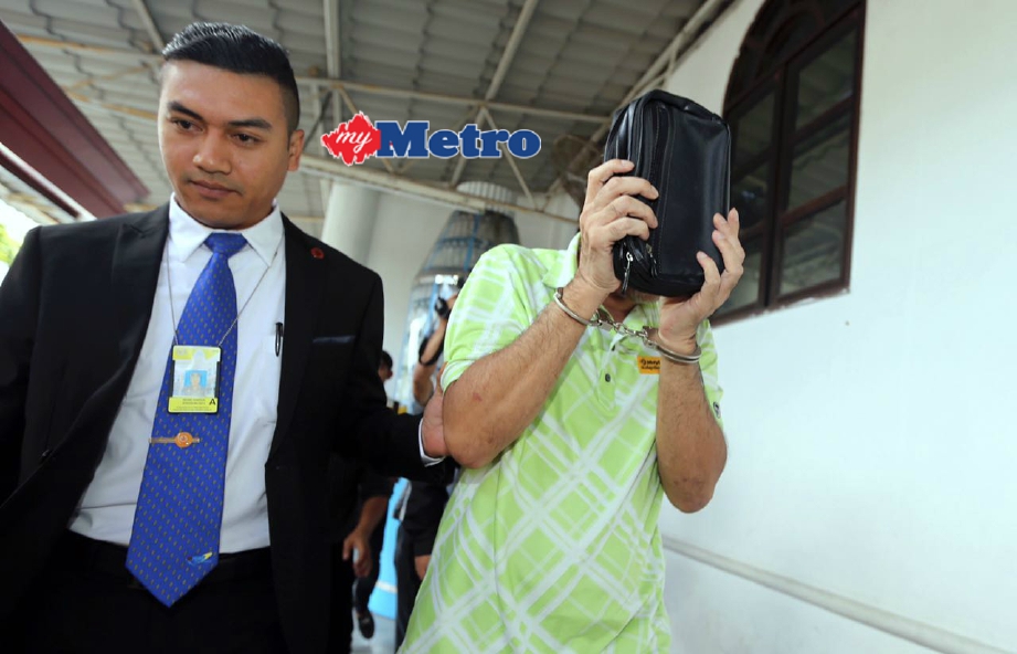 Awang Mohd Tahir diiringi anggota SPRM di Mahkamah Sesyen Kota Kinabalu untuk sebutan semula kes berhubung pengubahan wang haram membabitkan nilai RM61.57 juta. FOTO Malai Rosmah Tuah 
