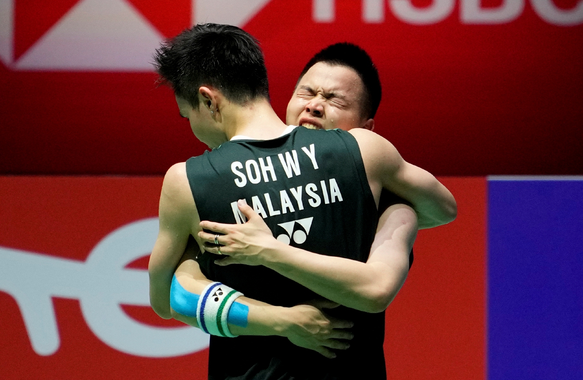 AARON dan Wooi Yik berpelukan selepas muncul juara dunia.  FOTO EPA