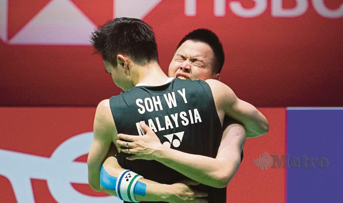 PEMAIN beregu negara, Aaron Chia (kanan) memeluk Soh Woo Yik selepas muncul juara di Kejohanan Badminton Dunia di Tokyo, Ahad lalu. FOTO EPA 