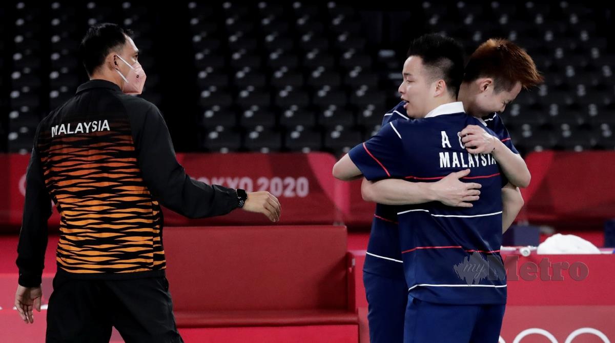 FLANDY (kiri) memberikan ucapan tahniah kepada Aaron Chia dan Soh Wooi Yik selepas menang gangsa acara badminton beregu lelaki di Tokyo 2020, Sabtu lalu. FOTO EPA 