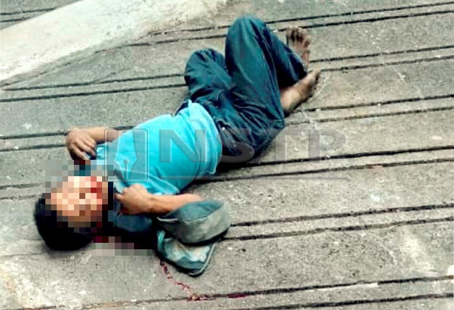 Suspek terbaring kaku selepas terjatuh dari tingkat dua bangunan Wisma Sandakan. FOTO Ihsan Pembaca