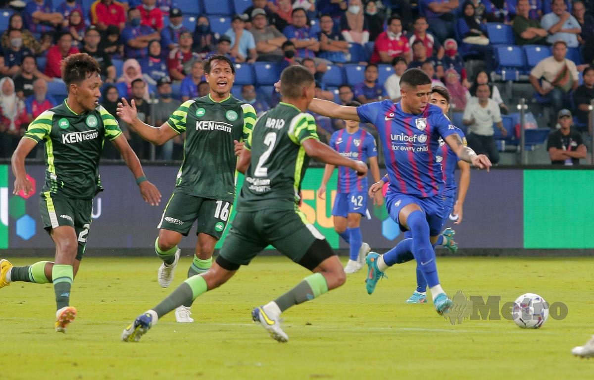 PEMAIN Melaka United (jersi hijau) cuba menghalang penyerang JDT, Bergson Da Silva (kanan) yang meledak hatrik pada perlawanan malam tadi. FOTO NUR AISYAH MAZALAN