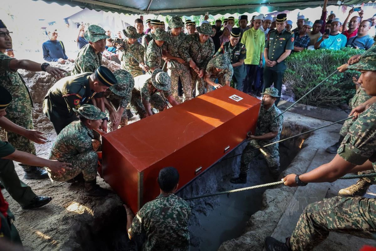 ANGGOTA ATM melakukan proses pengebumian Koperal Mohammad Nasri di tanah perkuburan Islam Masjid Pulau Mertajam Penaga. FOTO Bernama 