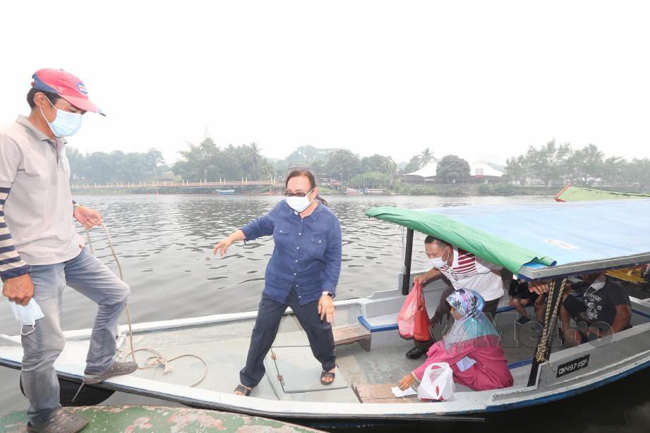 Pengusaha perahu tambang memakai topeng hidung dan mulut ketika beroperasi di Sungai Sarawak, Kuching disebabkan keadaan jerebu di bandar raya itu. Foto L Manimaran 