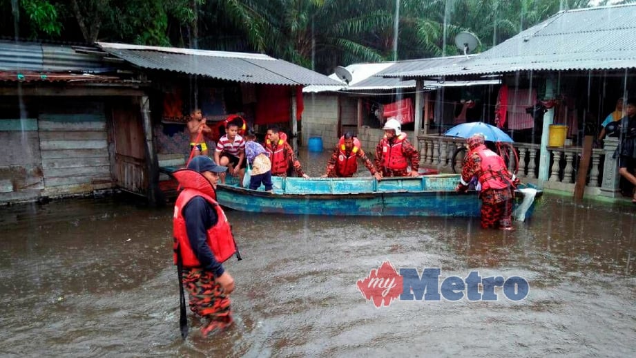 ANGGOTA Bomba dan Penyelamat Endau memindahkan mangsa banjir di kawasan Kampung Kelantan, semalam. FOTO Zul Ikhwan Muhamad