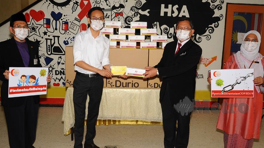 Dr Aman Rabu (dua dari kanan) menerima 10,000 pelitup muka daripada Pengurus Pembangunan Perniagaan Durio PPE Sdn Bhd, Kong Kian Hao (dua dari kiri) pada program penyerahan pelitup muka di Lobi Bangunan Poliklinik Hospital Sultanah Aminah Johor Bahru. FOTO ZAIN AHMED