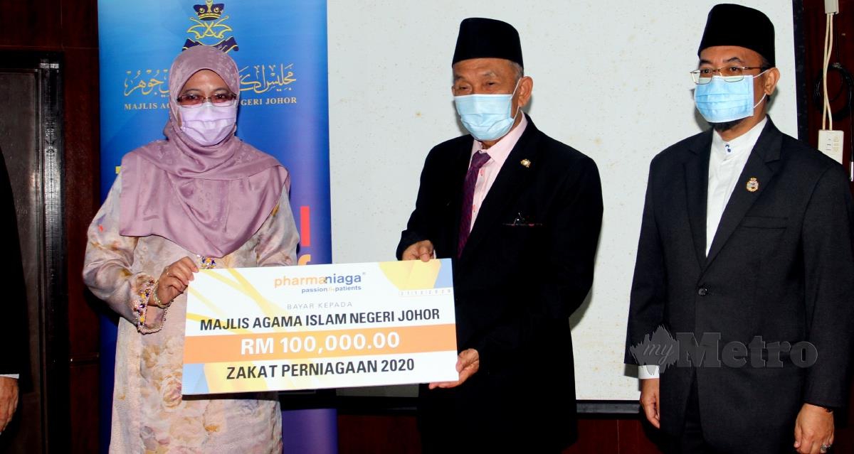 Tosrin Jarvanthi (tengah) menerima mock check Zakat Peniagaan daripada Pengerusi Pharma Niaga Sdn. Bhd. Datuk Dr Hafshah Hashim (kiri) pada Majlis Penyerahan Zakat Peniagaan di  Pusat Islam Iskandar Johor. FOTO ZAIN AHMED