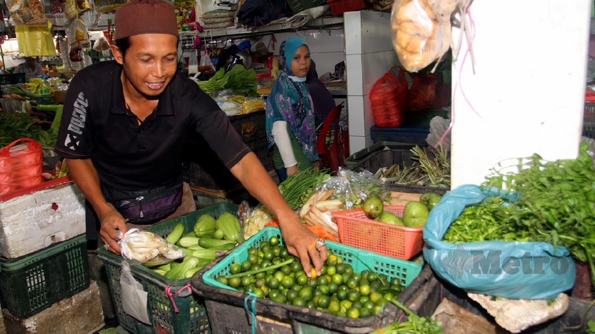 WAN Baharuddin menunjukkan buah limau kasturi yang mencatat kenaikan harga berbanding sayuran lain di pasar awam Pusat Perniagaan Baharu Pasar Taman Dahlia Johor Bahru.  FOTO Zain Ahmed