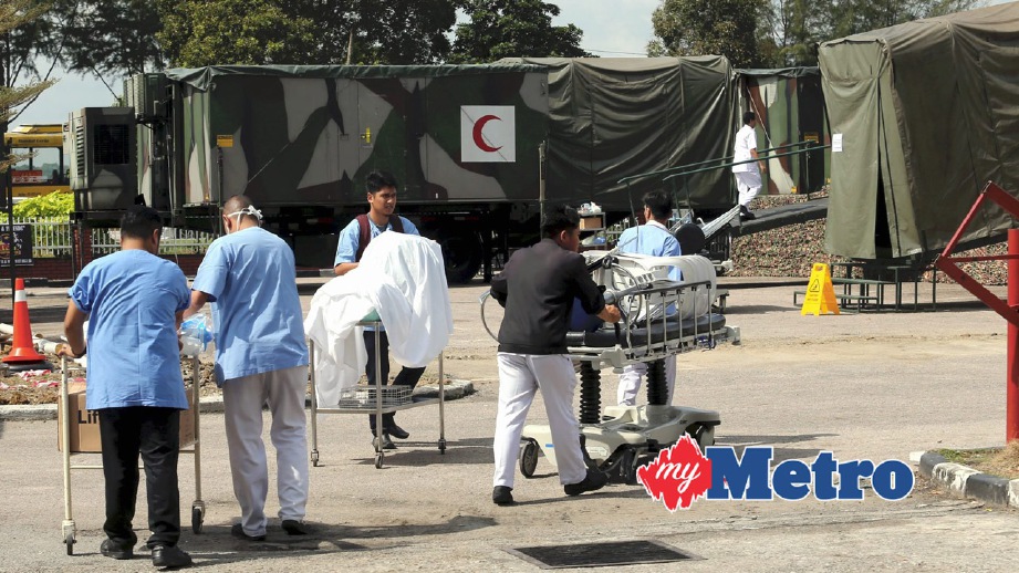 KAKITANGAN hospital membawa peralatan perubatan dari unit kecemasan ke dalam kontena Hospital Medan ATM. FOTO Zulkarnain Ahmad Tajuddin