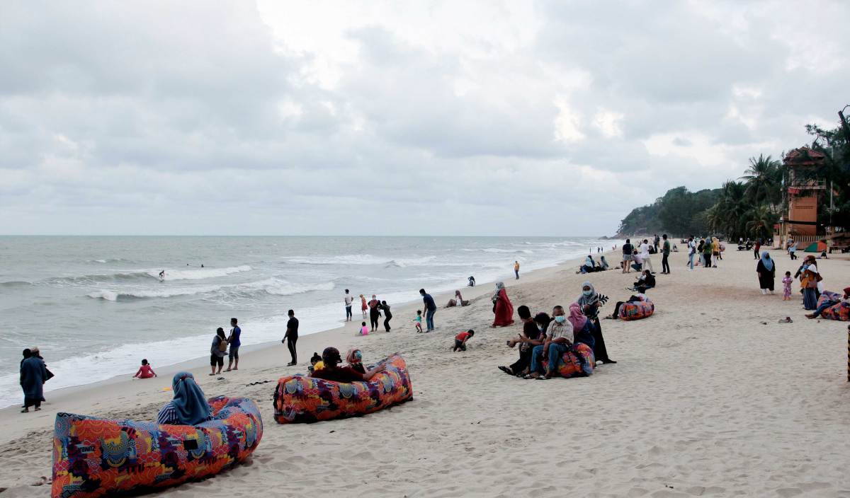 PENGUNJUNG bersantaian di Pantai Teluk Cempedak yang merupakan pantai peranginan popular di Kuantan. FOTO BERNAMA
