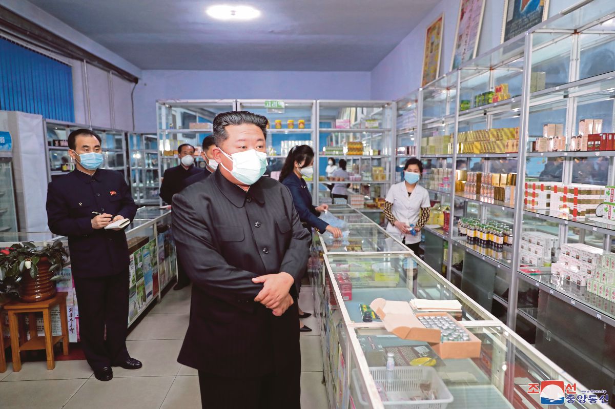 JONG Un memakai pelitup muka ketika melawat sebuah farmasi di Pyongyang. FOTO EPA 