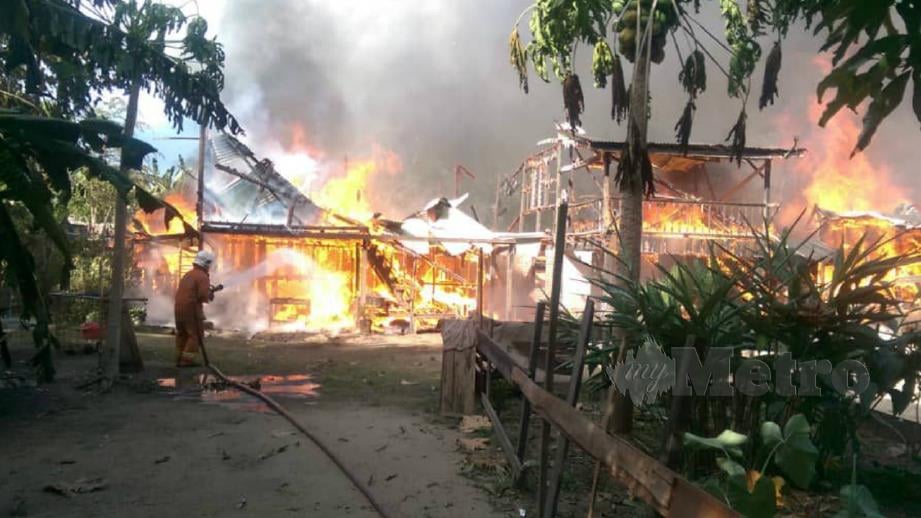 ANGGOTA Bomba memadamkan kebakaran empat kediaman di Kampung Limbawan, Keningau. FOTO Ihsan Bomba.