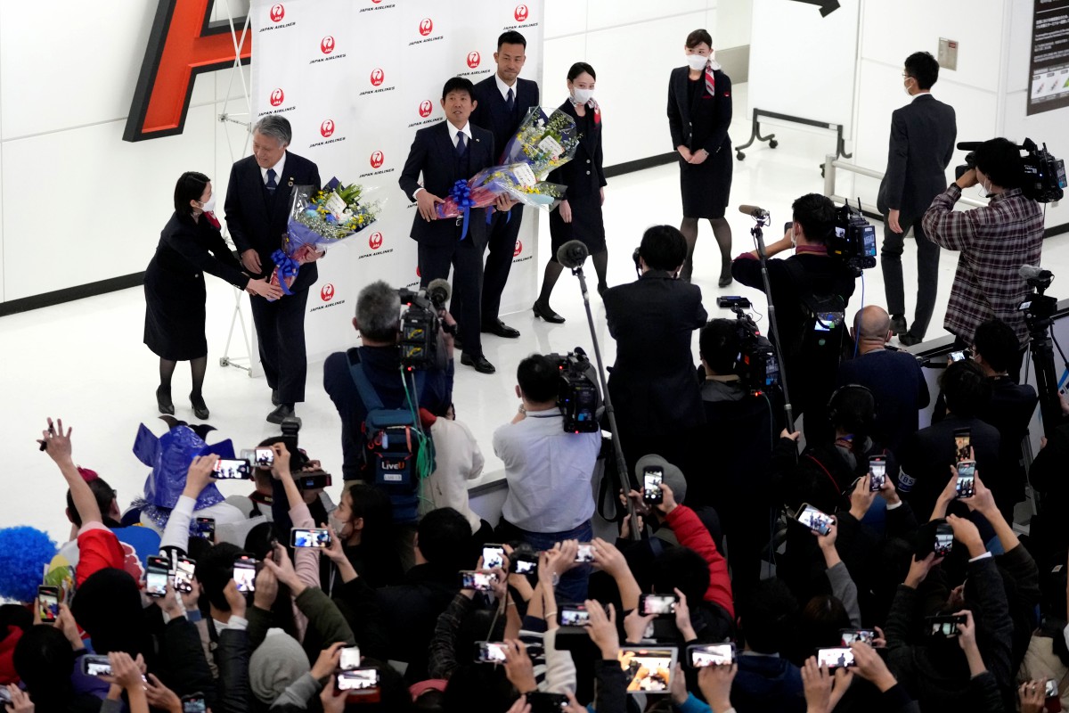 Jurulatih Jepun, Hajime Moriyasu (tengah) dan Maya Yoshida menerima jambangan bunga ketika menyokong meraikan kepulangan skuad kebangsaan Piala Dunia Qatar di Narita. FOTO AP