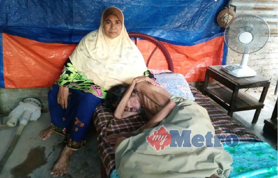 FARIDAH menemani abangnya Hamdan yang mengalami masalah mental dan tinggal di bawah khemah di dalam rumah pusaka yang sangat uzur di Kampung Sg Korok, Alor Biak. Foto STR/NOORAZURA ABDUL RAHMAN