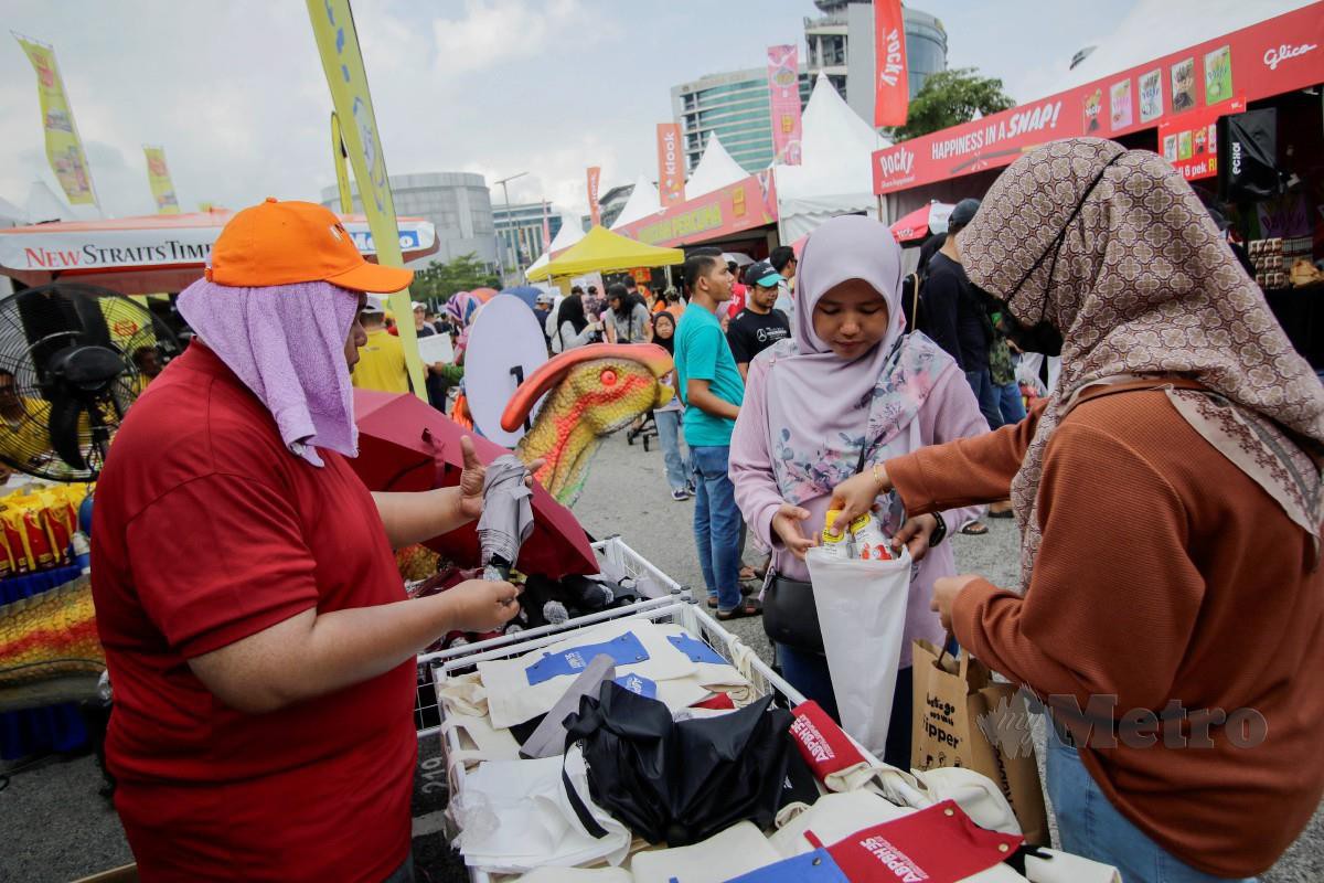 PENGUNJUNG membeli produk eksklusif dari reruai NSTP pada Karnival Jom Heboh di Putrajaya. FOTO Aizuddin Saad