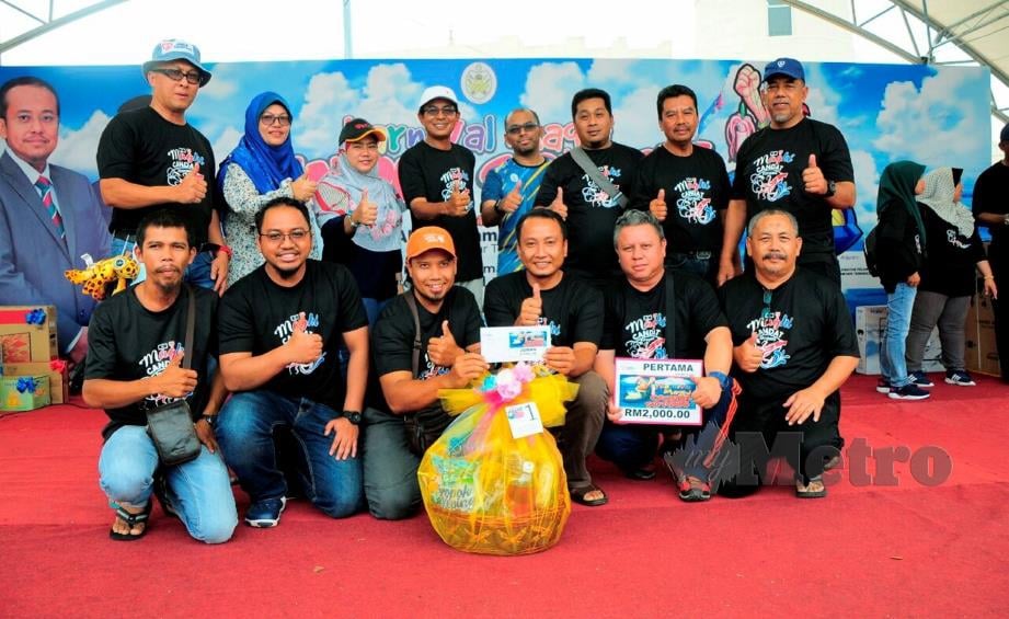 SHAHRIZ (barisan belakang, empat dari kanan)  barisan belakang) bersama juara kategori tangkapan sotong terbanyak pada majlis penyampaian hadiah sempena majlis penutup Karnival Maghi Candat Sotong di Taman Tamadun Islam (TTI) Kuala Terengganu, hari ini. FOTO Baharom Bakar.
