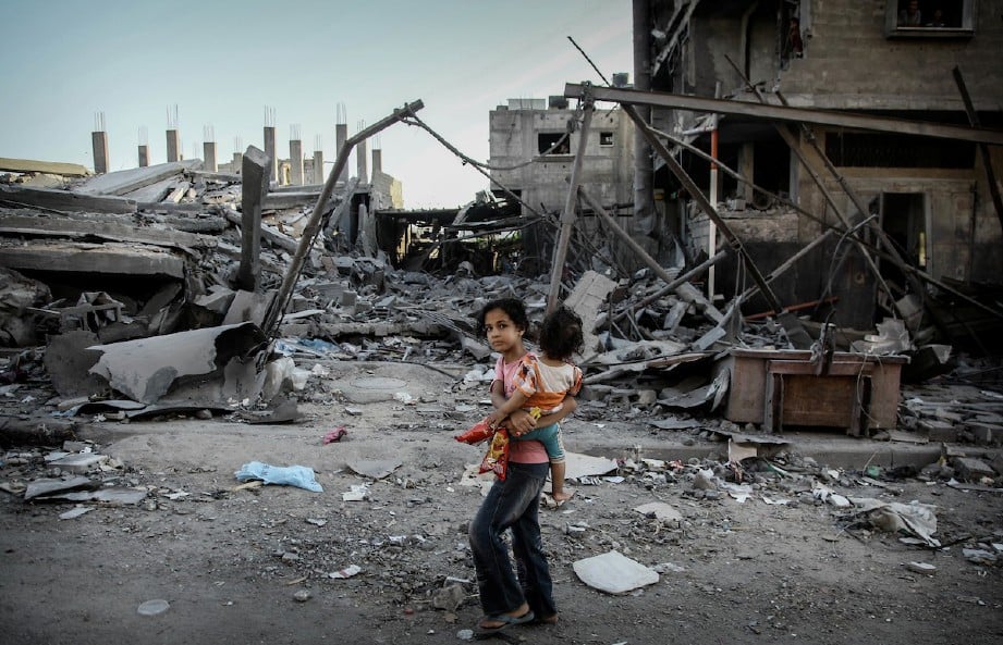 KANAK-kanak Palestin berjalan di depan runtuhan bangunan. FOTO/AGENSI
