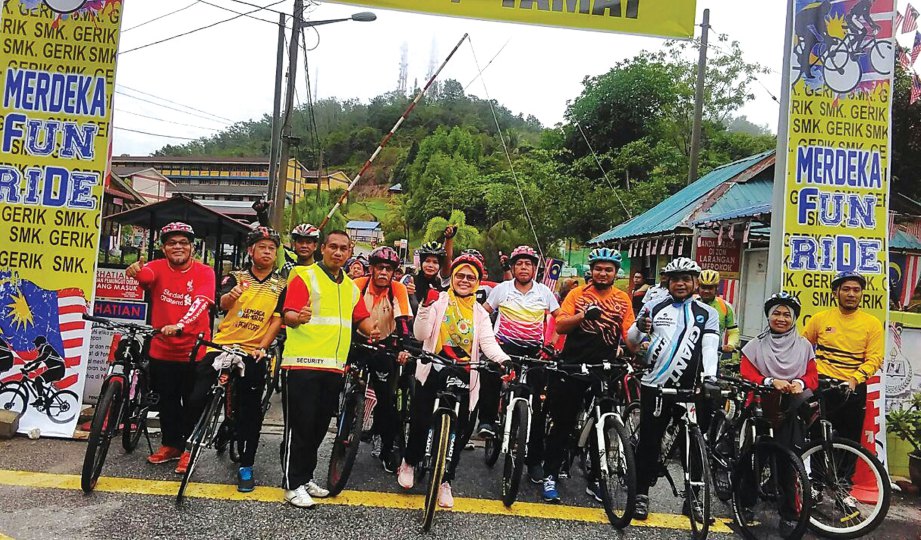 SALBIAH (tengah) dan Rosli (lima dari kanan) bersama 300 peserta program Kayuhan Basikal Sambil Beramal pada acara Merdeka Fun Ride 2017 Sempena Sambutan Bulan Kemerdekaan dan Hari Malaysia di Gerik, baru-baru ini.