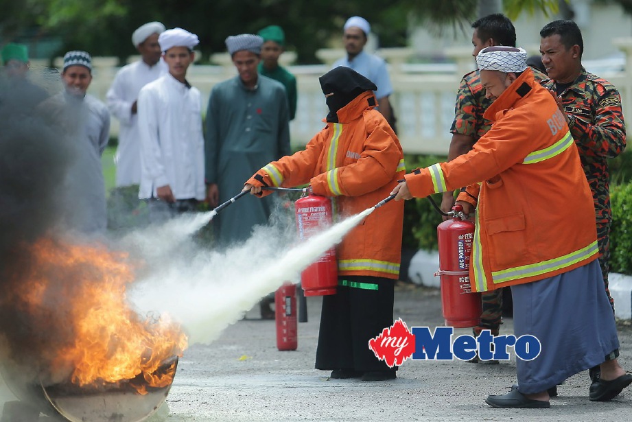ANGGOTA bomba mengajar cara menggunakan alat pemadam api jika berlaku kebakaran. FOTO Fathil Asri