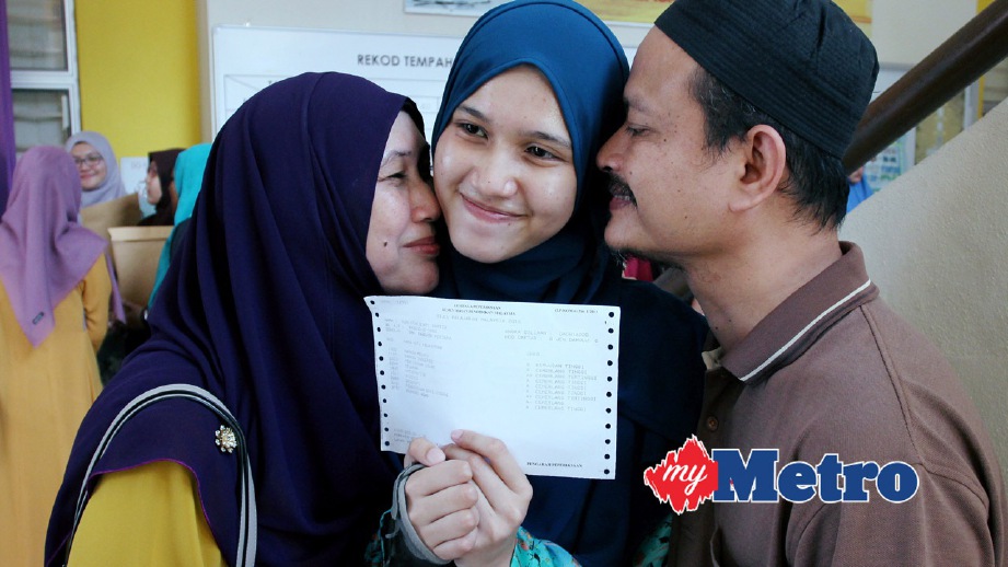 NURIFFAH dipeluk ibu bapanya, Ramizu Ghazali, 46 (kanan) dan ibunya, Norasyikin di SMK Panchor Perdana. FOTO Nik Abdullah Nik Omar