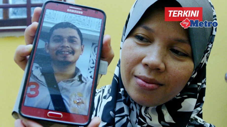 NORIAH tabah sambil menunjukkan gambar arwah suaminya, Muhamad Shukri Husin, 34, yang maut akibat ditetak. FOTO Faris Zainuldin