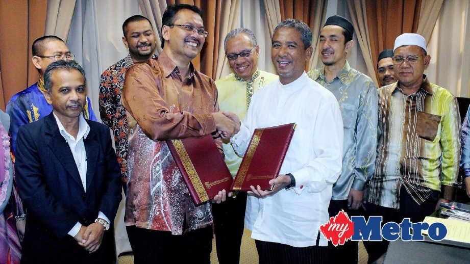 NIK Mohd Azlan (tiga kanan)  bersalaman dengan Wan Kamal  (dua kiri) selepas Majlis Menandatangani Surat Hasrat. FOTO Nik Abdullah Nik Omar