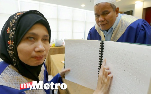 PESERTA Terbaik Kategori Wanita Kelas al-Quran Braille 2015, Wan Nur Aini Wan Ali, 36, (kiri) bersama Rahimin menunjukkan cara membaca al-Quran Braille. FOTO Fathil Asri